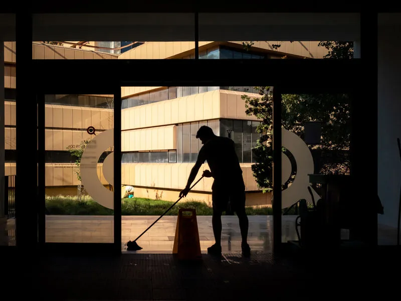 Janitorial technician cleaning a healthcare corridor